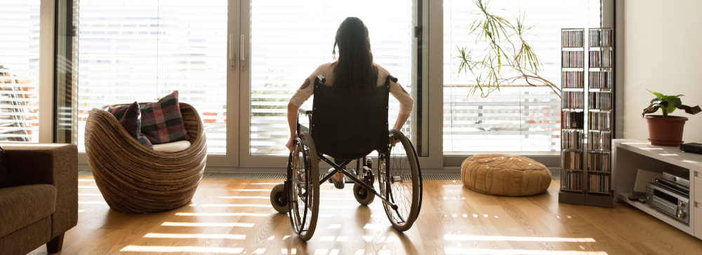 A young woman in a wheelchair looking out of the window