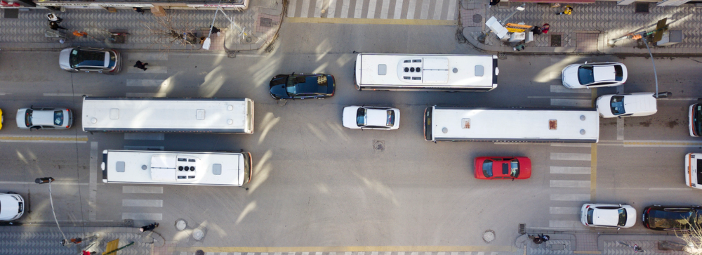 An aerial shot of a busy city intersection with several busses driving