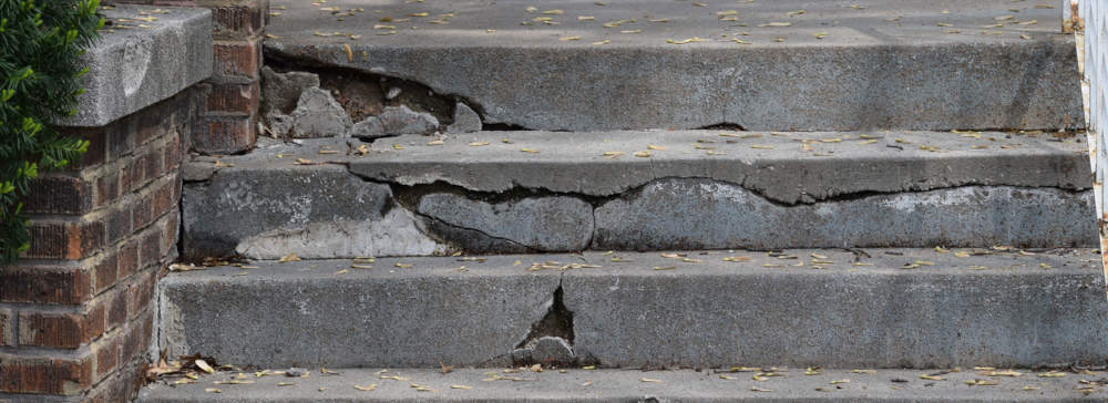 Cracked concrete stairs representing a premises liability hazard
