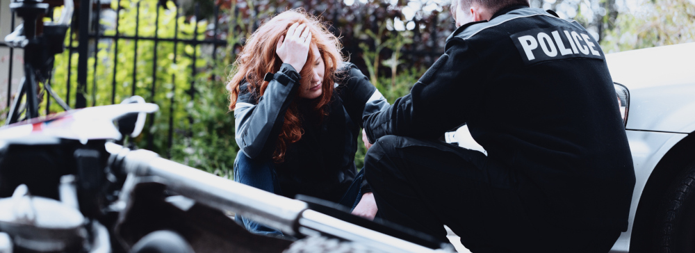 Police officer interviewing a woman after a motorcycle accident