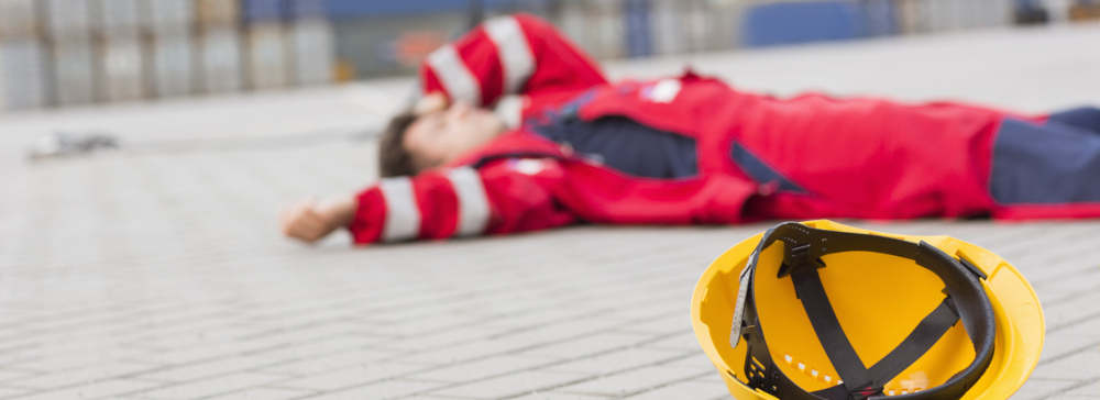 An injured worker laying on the ground after a construction accident