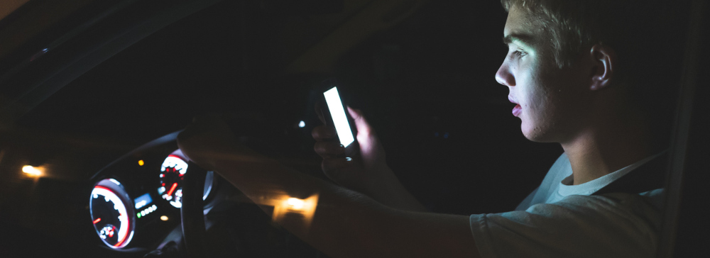 Teen driver engaging in distracted driving by texting while driving