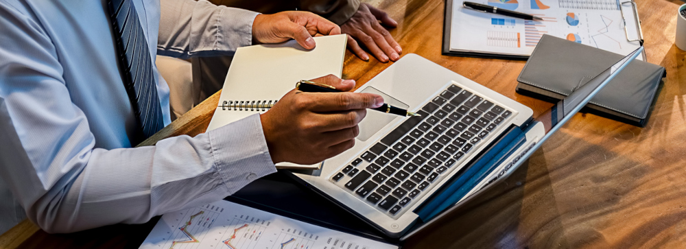 Lawyer at a table pointing to their laptop screen during a meeting