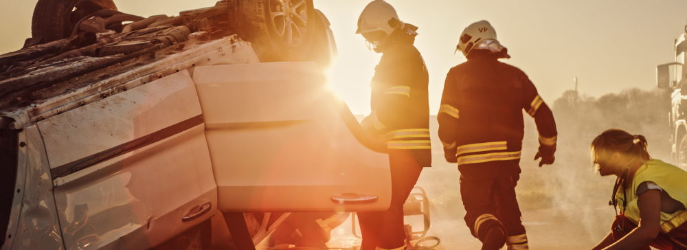 Firefighters assisting an overturned vehicle after a severe car accident