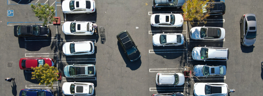 Aerial view of a parking lot with numerous cars