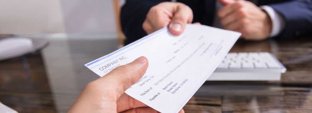 Person handing over a settlement check after an accident