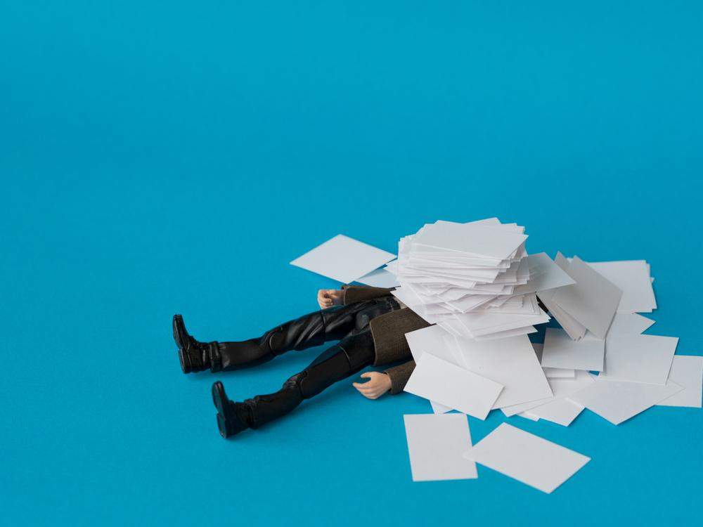 person drowning in paperwork
