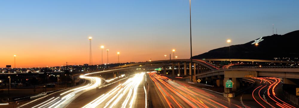 An aerial view of I-10 in El Paso at night with traffic heading towards downtown