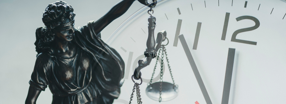 Silver statuette of Justice holding the scales of justice in front of a clock, symbolizing personal injury lawsuit statute of limitations