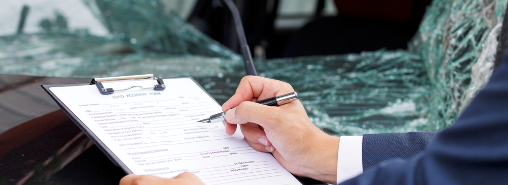An attorney reviewing damage to a car after a car accident