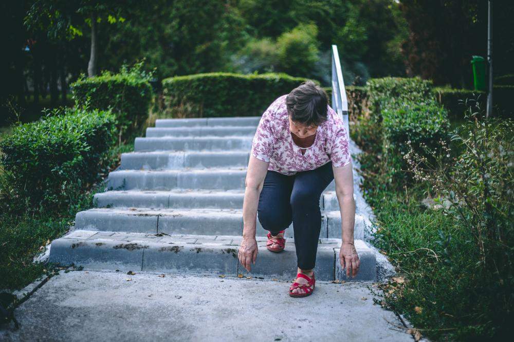 senior woman slipping on stone park stairs