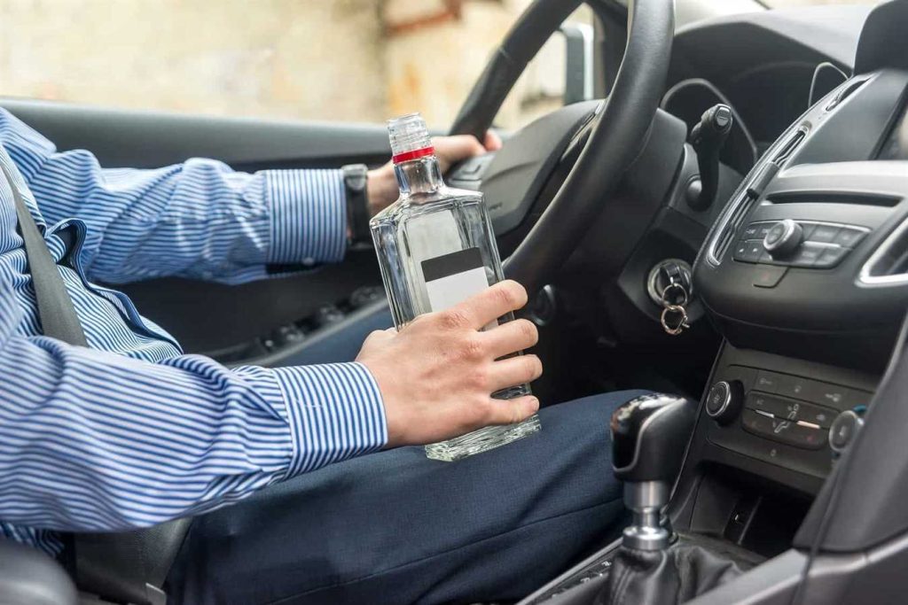 Bottle of alcohol beverage in man's hands