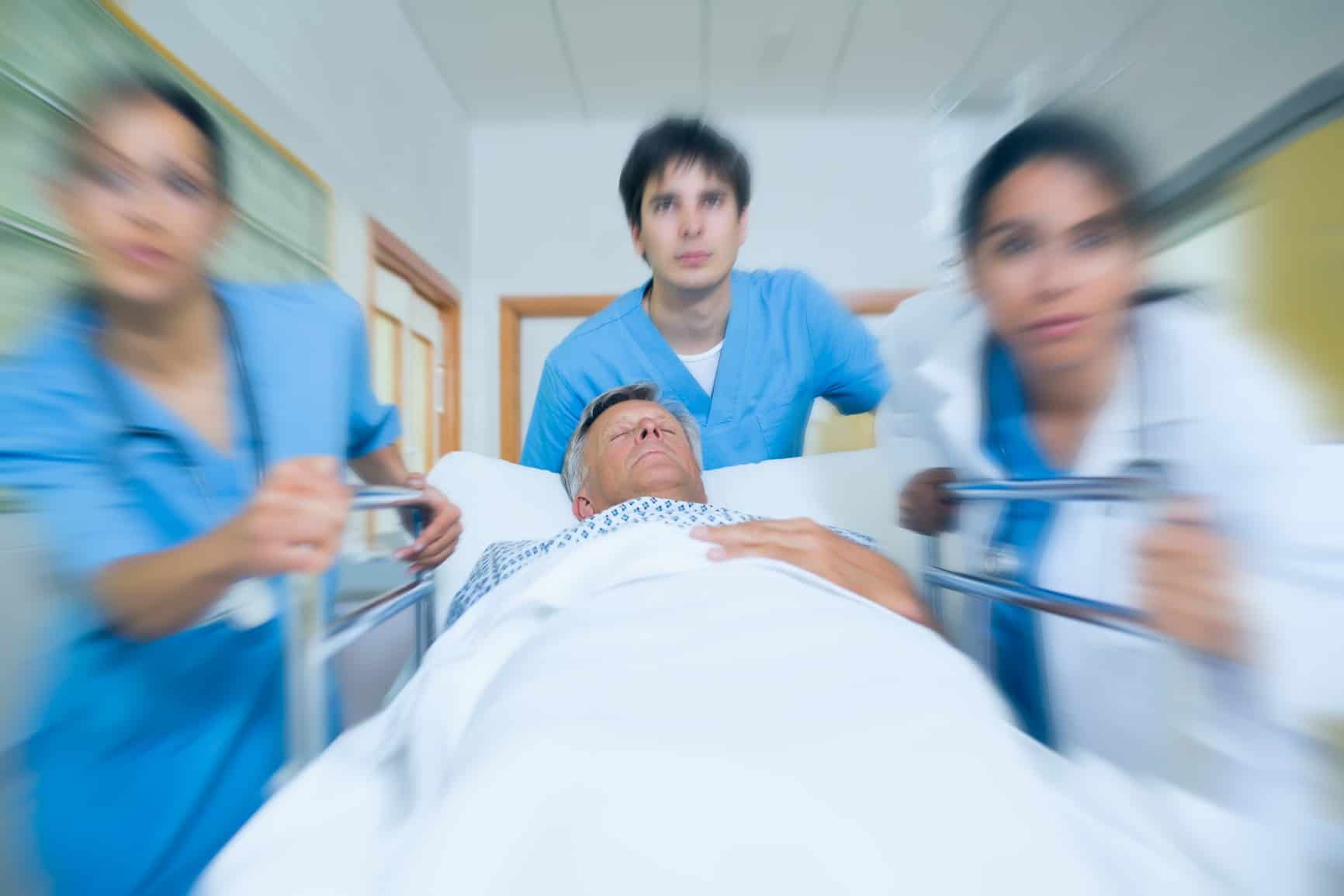 Team of doctor running in a hospital hallway with a patient in a bed