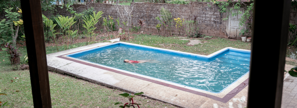 A woman in a backyard swimming pool, symbolizing potential swimming pool negligence